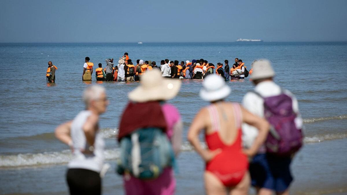En la playa de Hardelot (Pas-de-Calais), personas exiliadas esperan un “taxi lancha” bajo la mirada de los turistas, el 29 de julio de 2026.