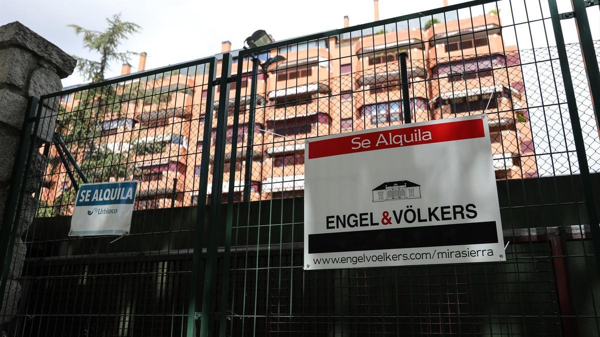 En la valla de una urbanización, se ven colgados dos carteles de 'Se alquila'.