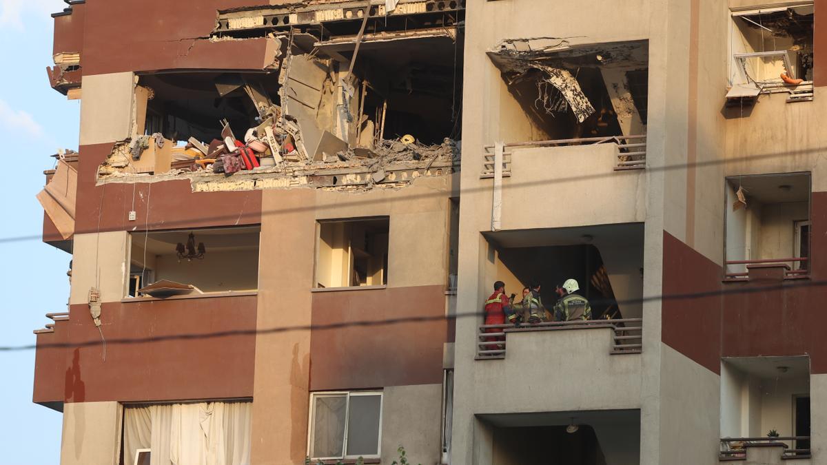 Bomberos trabajan en el interior de un edificio tras un ataque israelí al norte de Teherán.