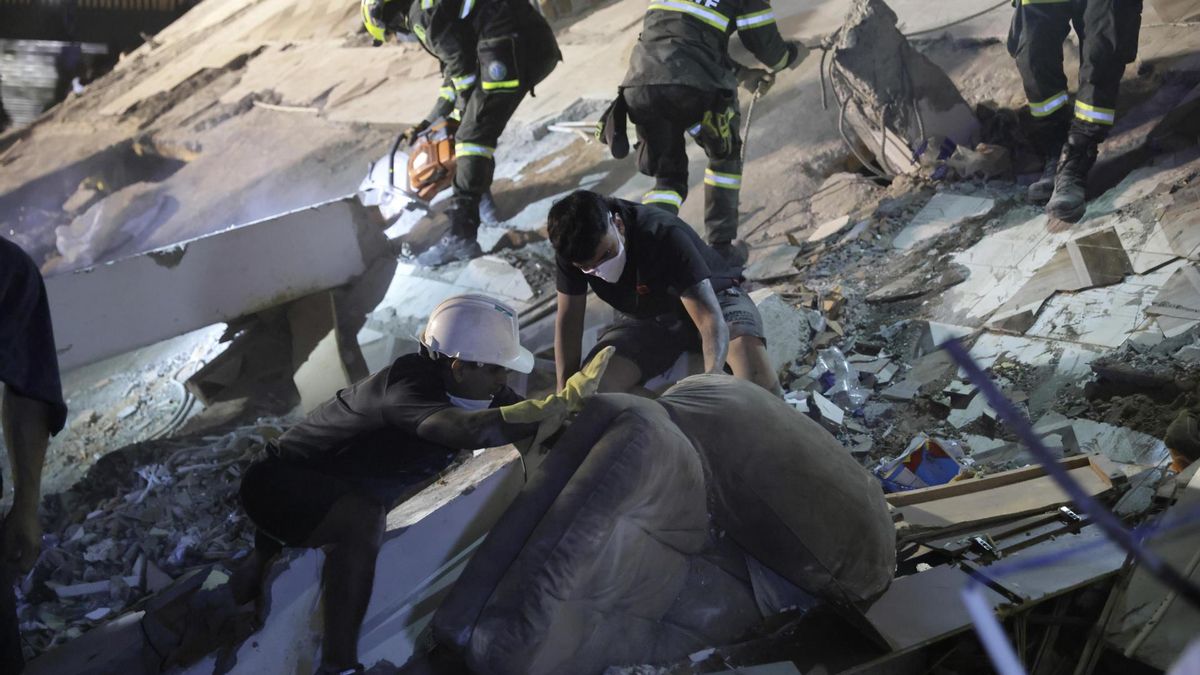 Integrantes de la Policía de Búsqueda y Rescate y personas realizan labores de búsqueda en una edificación frente al Parque la Libertad este lunes, en Pereira (Colombia).