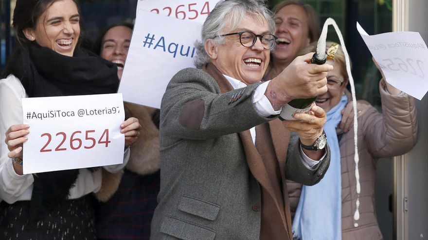 El titular de la administración número 97 de Barcelona, Pedro Fortuño, celebra los décimos del número 22.564, agraciado hoy con el primer premio del El Niño.