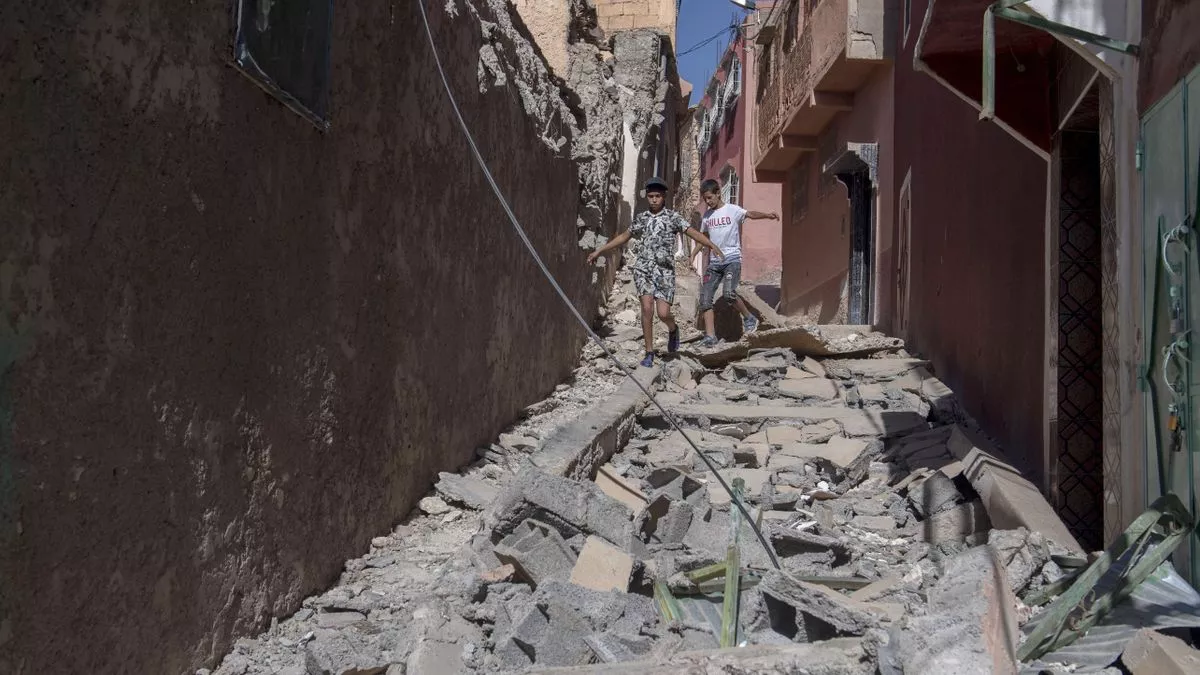 Dos niños caminan entre los escombros de edificios dañados tras el terremoto en Marrakech
