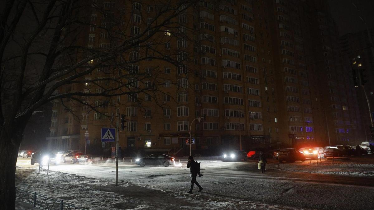 Personas caminan por las calles de Kiev en medio de un corte de electricidad.