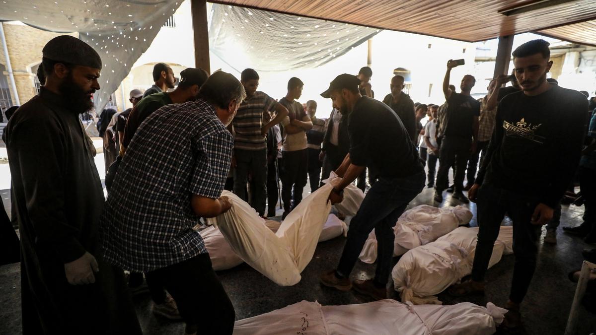 Familiares palestinos de la familia Abu Shaban rodean los cuerpos de sus seres queridos en el Hospital Bautista Al Ahli de la ciudad de Gaza.