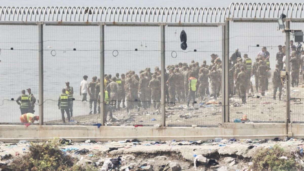 Fuerzas auxiliares de Marruecos impiden la llegada al espigón de la playa del Tarajal que separa Ceuta de Marruecos.