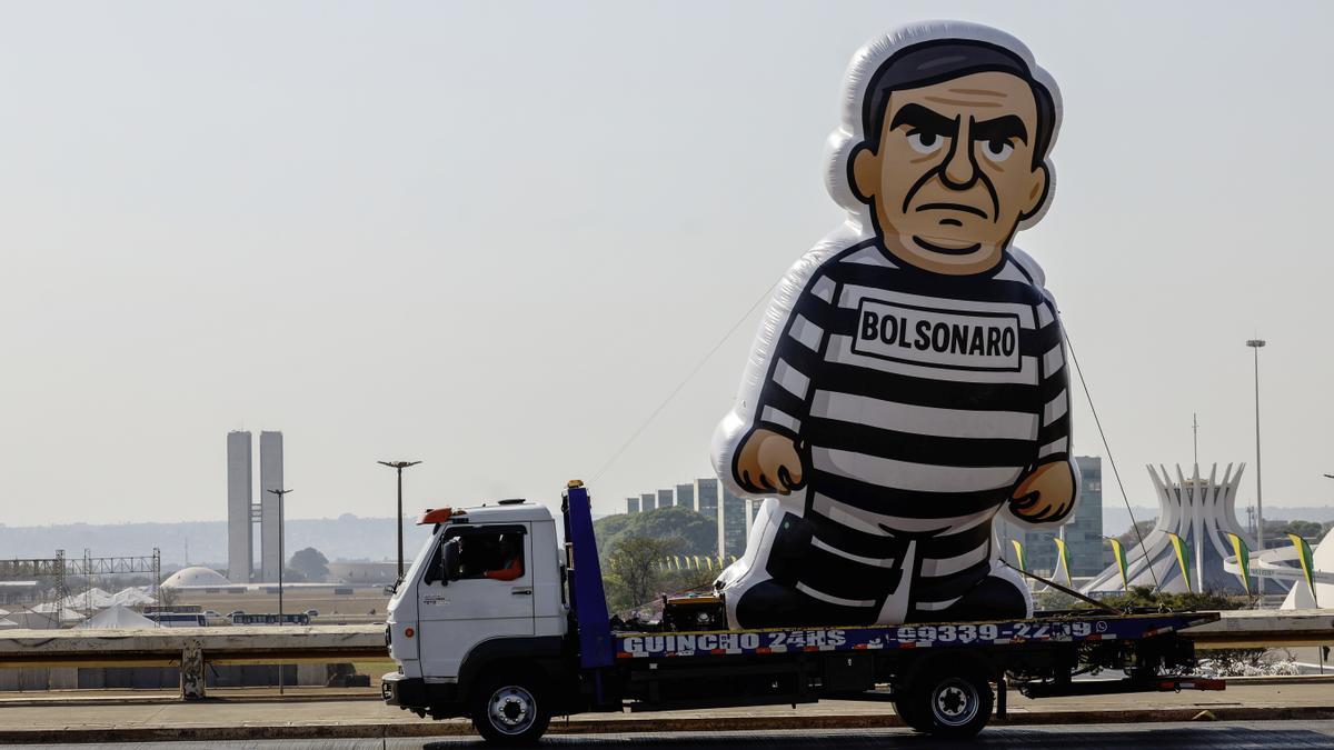 Fotografía que muestra un muñeco alusivo al expresidente de Brasil Jair Bolsonaro durante un desfile este viernes, en Brasilia.