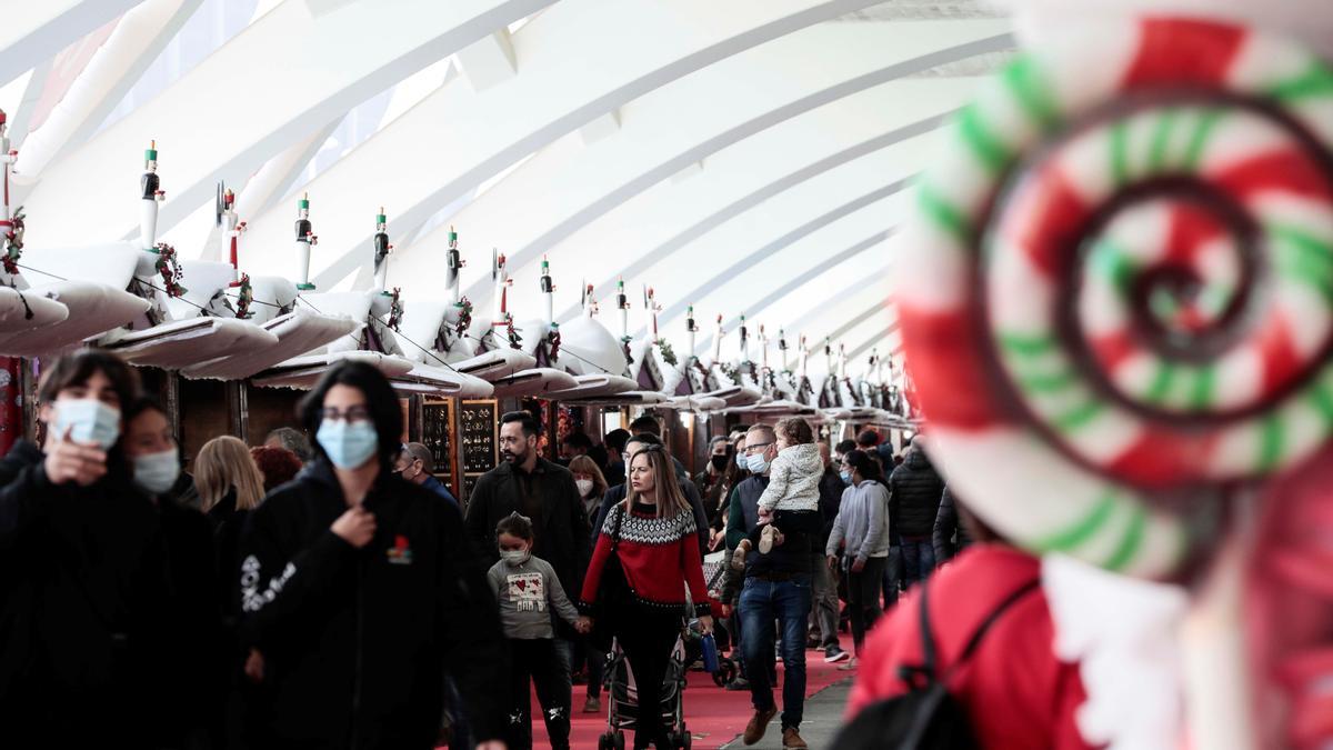 Decenas de personas pasean por un mercadillo navideño situado en la Ciudad de las Artes y las Ciencias de València.