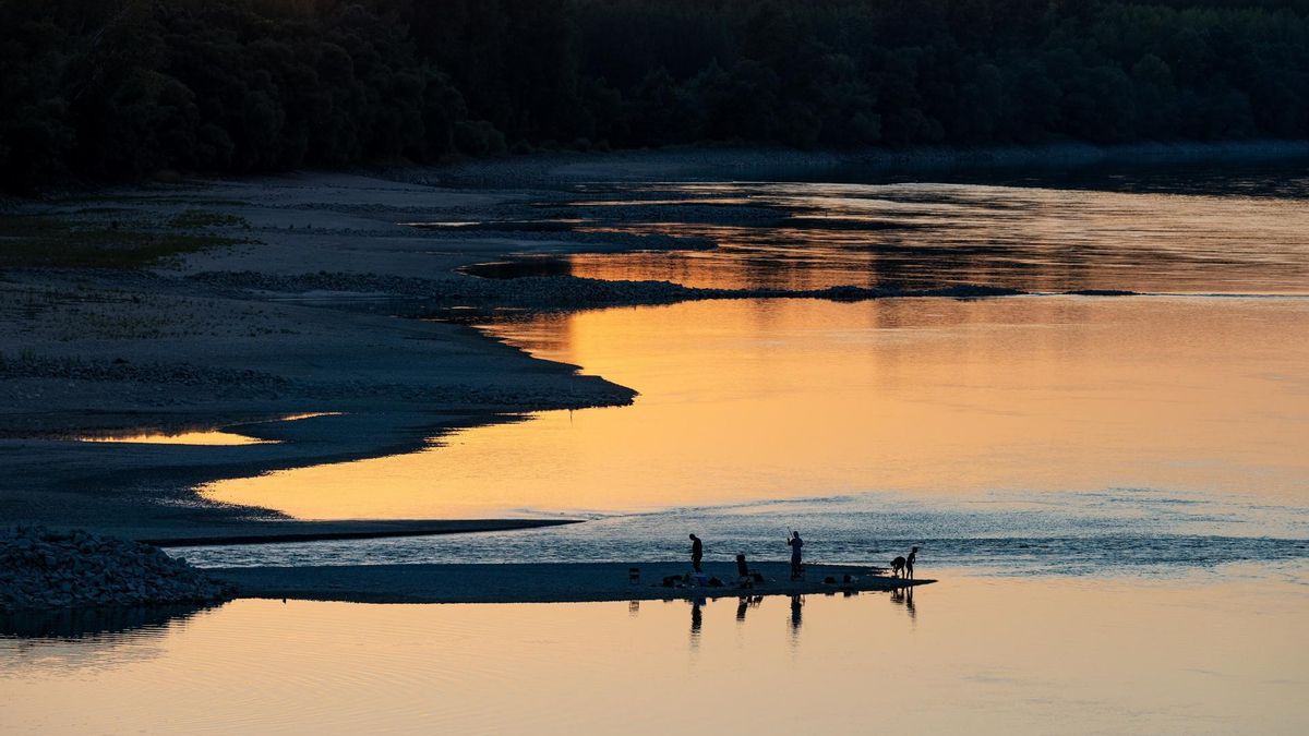 Pescadores en un banco de arena descubierto por el bajo nivel del agua del Danubio en Vamosszabadi, noroeste de Hungría.