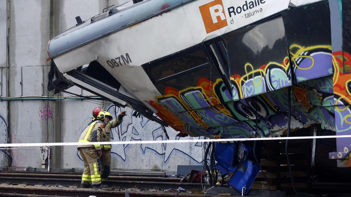 Varios bomberos trabajan en la zona cero del accidente de tren ocurrido ayer en Gelida.