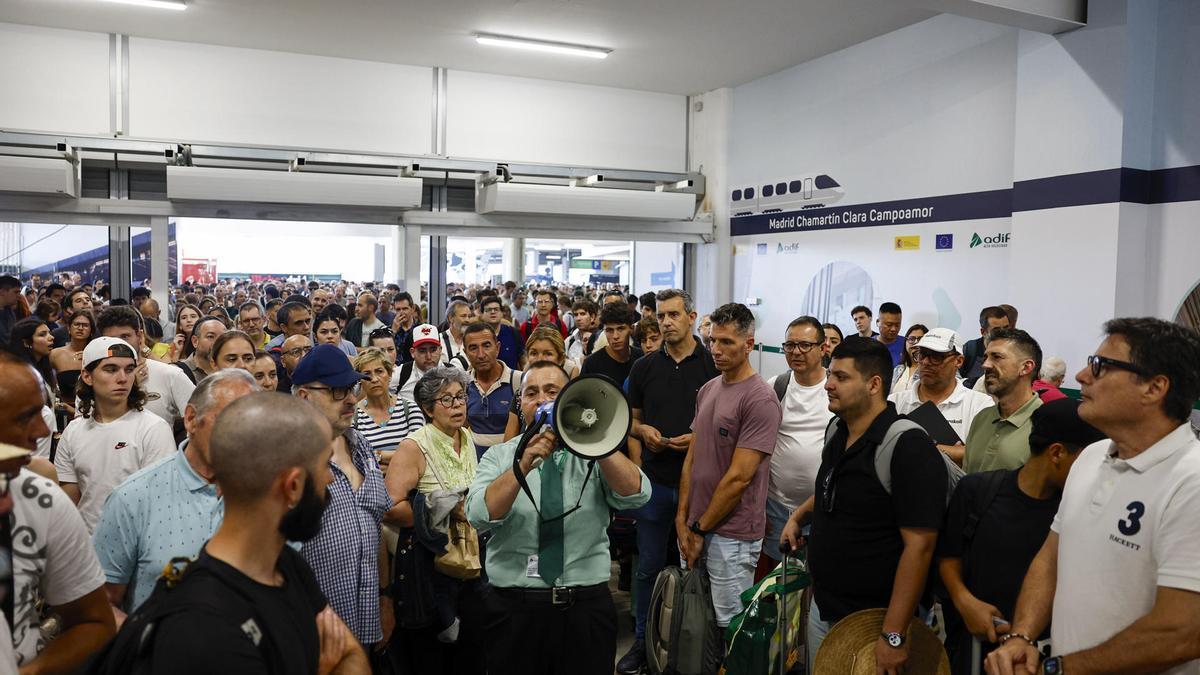 Una multitud se concentra alrededor de un trabajador de Adif en la Estación de Chamartín