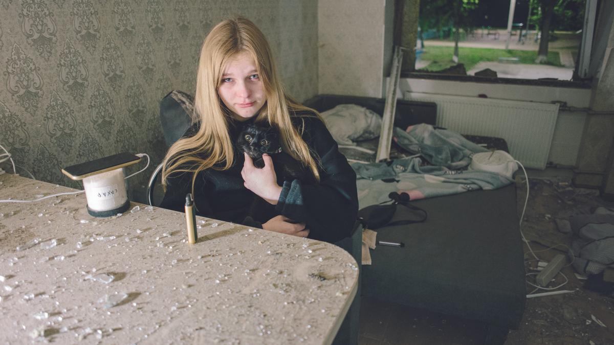 Una chica posa con su gato en el interior  de su apartamento destruido en Járkiv, Ucrania, el pasado 2 de mayo.
