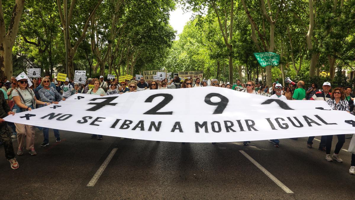 Varias personas sostienen una pancarta con el número de fallecidos en las residencias de Madrid.