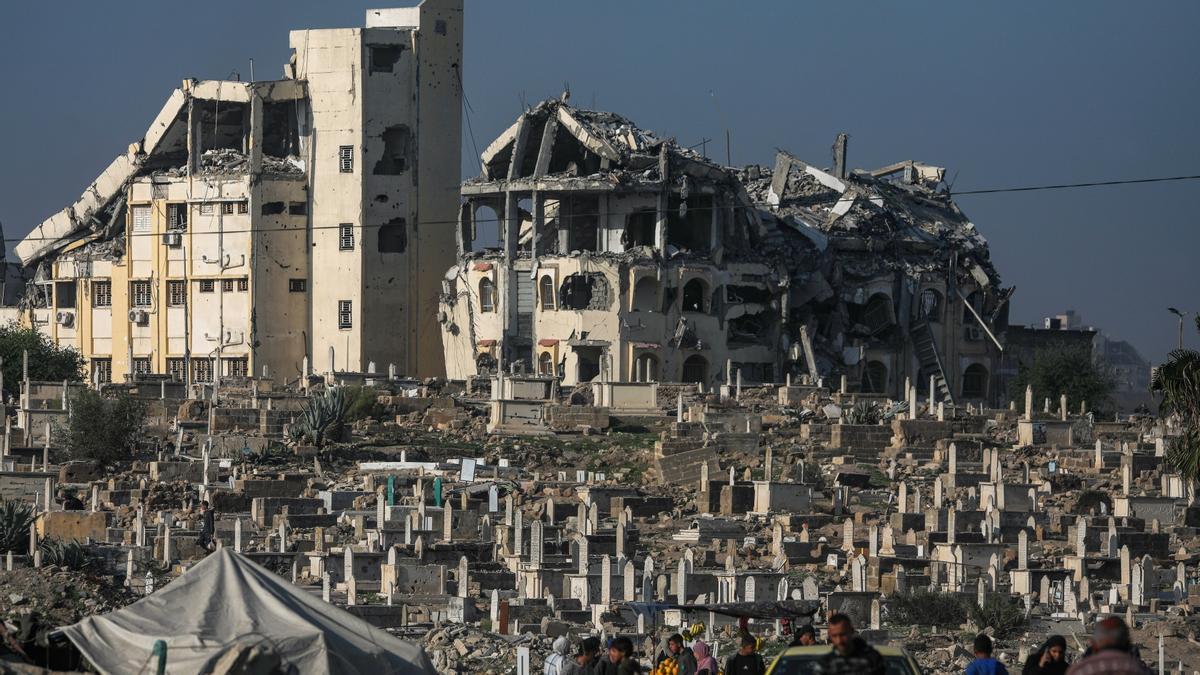 Palestinos caminan cerca del antiguo cementerio destruido en la ciudad de Gaza, Franja de Gaza, 4 de diciembre de 2025.