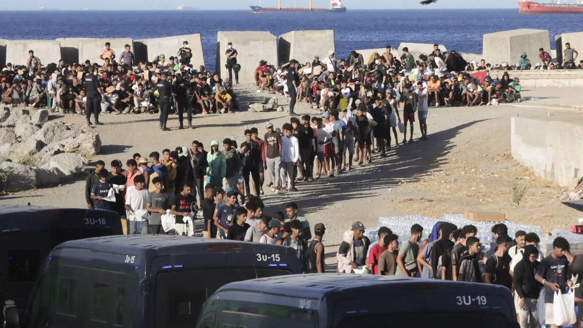 Cola de migrantes en la playa del Trampolín de Ceuta a la esperade recibir alimentos de Cruz Roja.