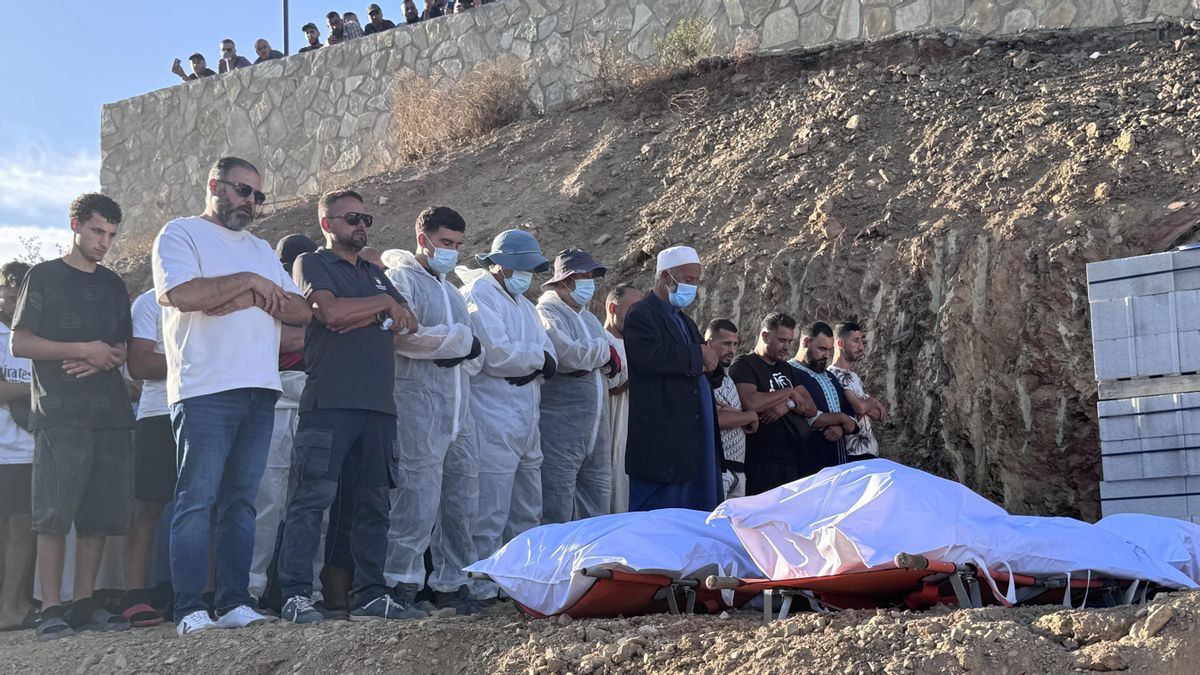 Un imán dirige el rezo previo a la inhumación de cuatro de los fallecidos tras intentar cruzar a nado la frontera de Ceuta.