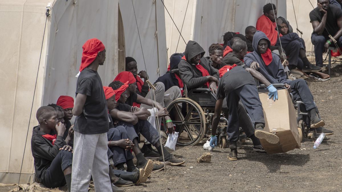 Varios migrantes esperan para ser trasladados al puerto de La Estaca, en El Hierro, Canarias (España).