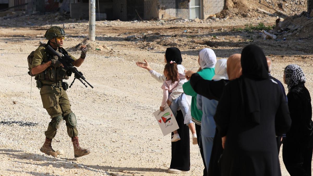 Soldados israelíes impiden a palestinos desplazados del campo de refugiados de Nur Shams intentar regresar a su campo, mientras continúa la operación militar israelí, cerca de la ciudad cisjordana de Tulkarem