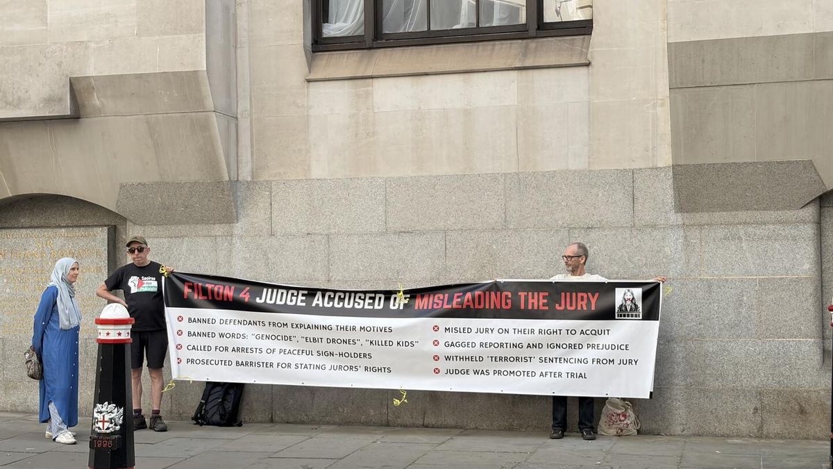 Imagen de dos personas sujetando una pancarta durante el juicio a Filton 4.