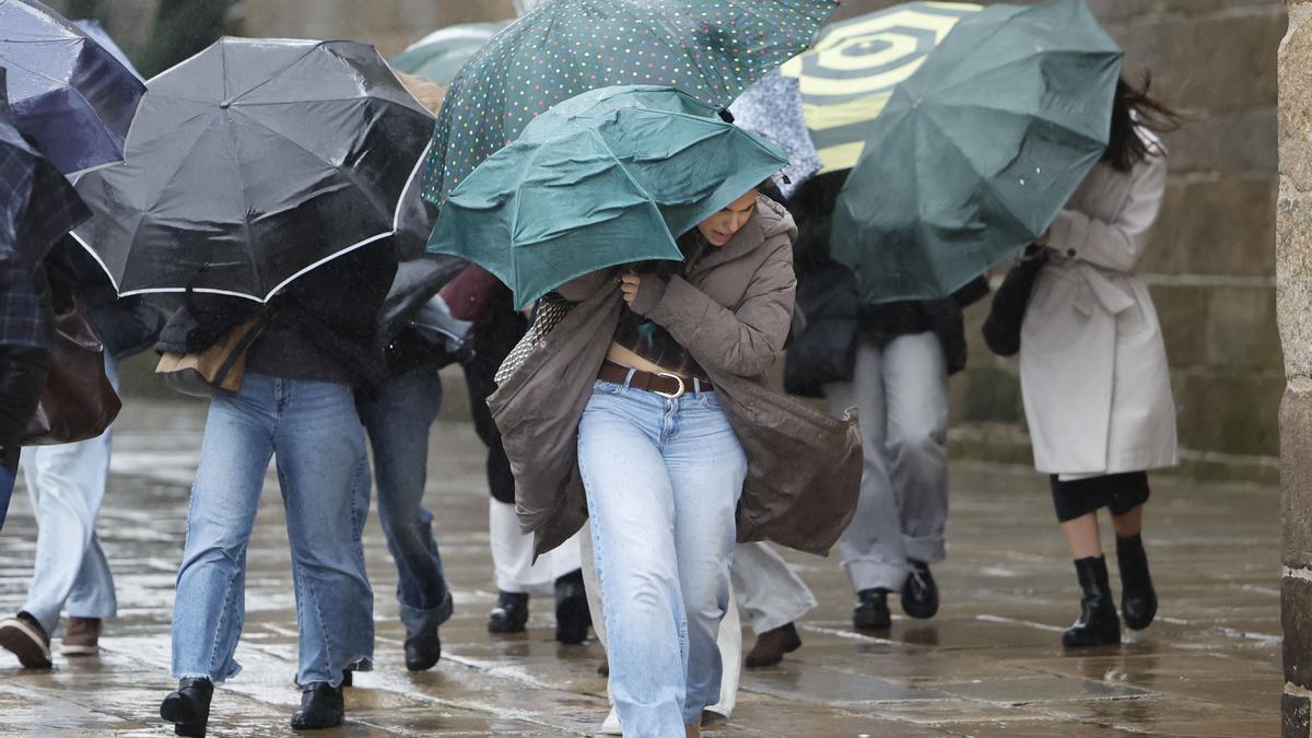Varias personas se protegen de la lluvia, ese miércoles en Santiago de Compostela.
