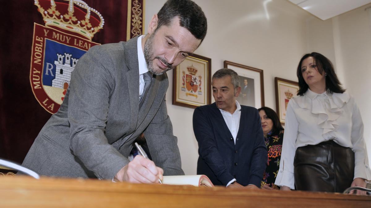 El ministro de Derechos Sociales, Consumo y Agenda 2030, Pablo Bustinduy, firma en el libro de Honor del Ayuntamiento de La Roda (Albacete).