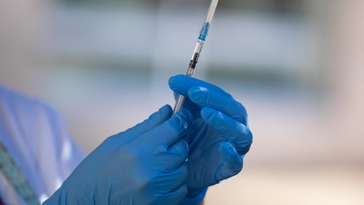 Una sanitaria prepara una vacuna.